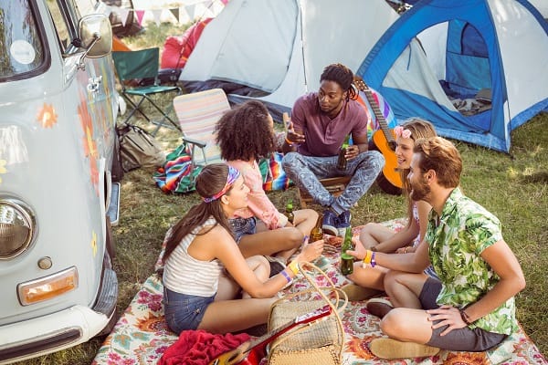 Friends having a drink together whilst camping at festival