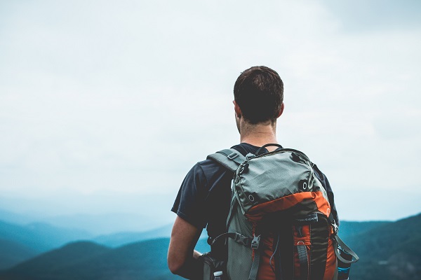 Backpacker looking at view from mountain side